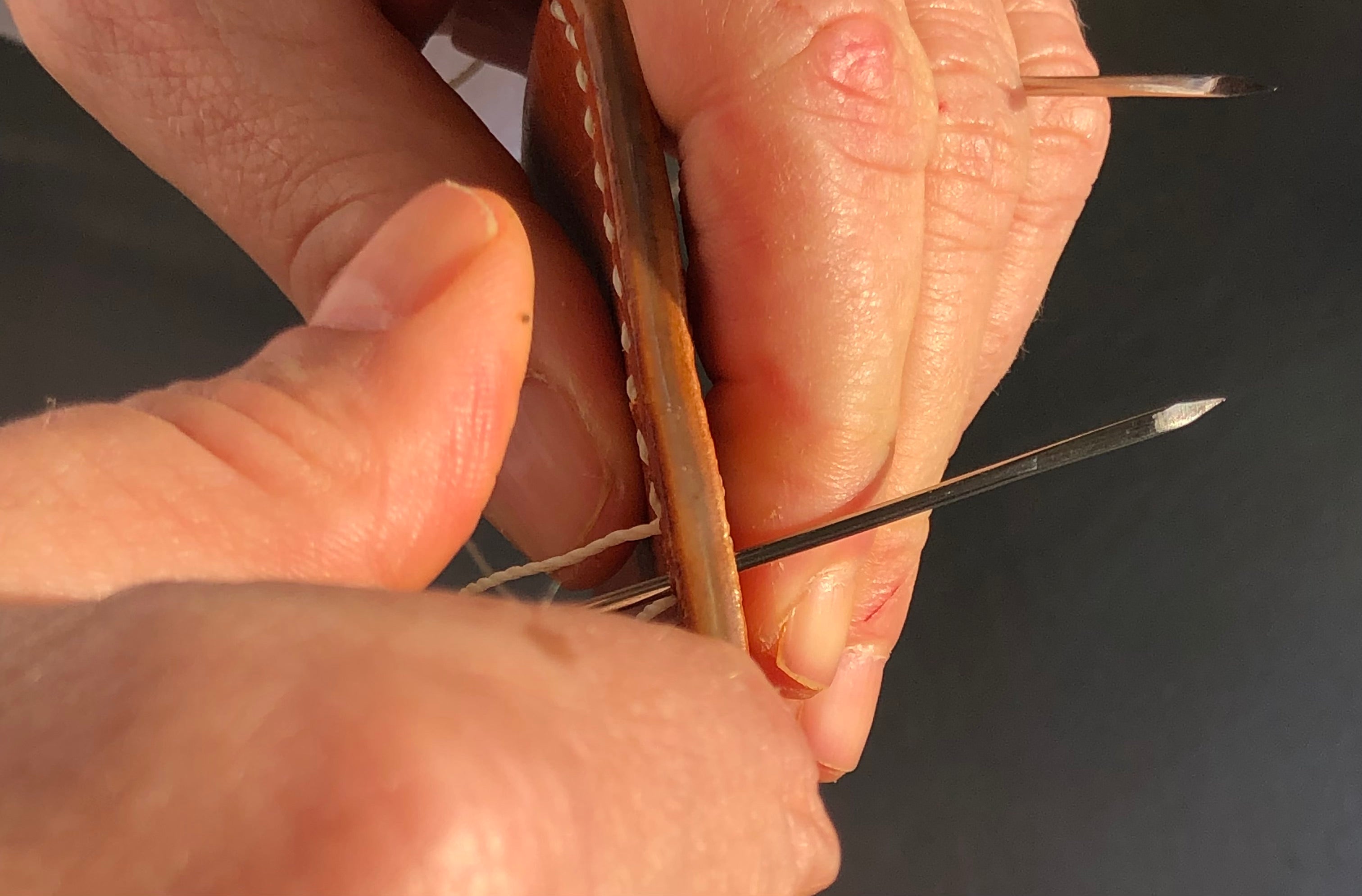 Hands sewing with two needles